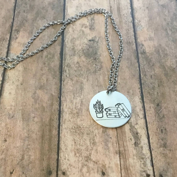 Stack of books with plant circular pendant